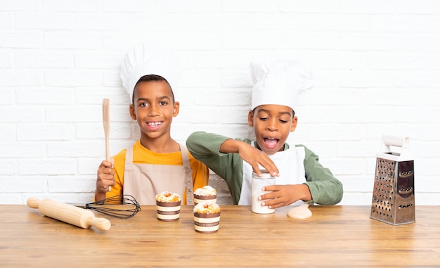 Dois filhos de irmãos afro-americanos vestidos como chef