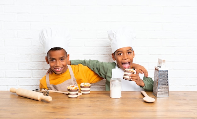 Dois filhos de irmãos afro-americanos vestidos como chef