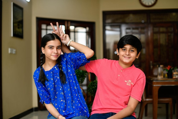 dois filhos pequenos, menino e menina, irmão frente, pose modelo indiano do paquistanês
