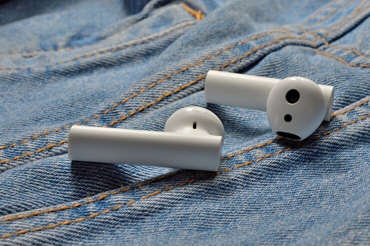 Foto dois fones de ouvido sem fio brancos sobre jeans