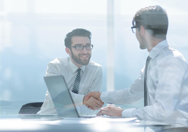 Dois funcionários apertando as mãos no Deskphoto com espaço de cópia