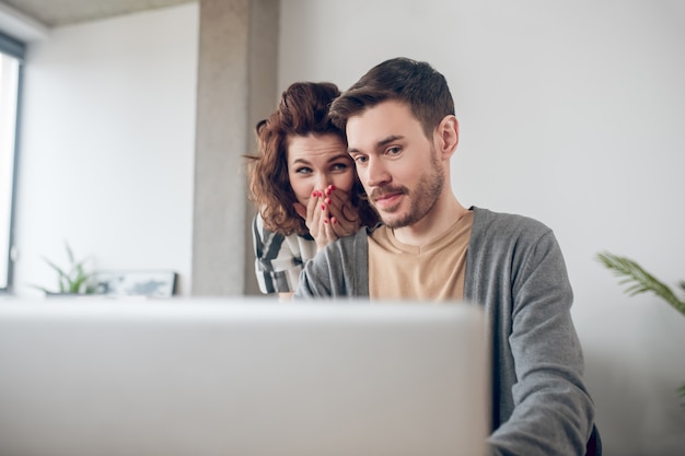 Dois funcionários de escritório surpresos lendo uma mensagem de e-mail