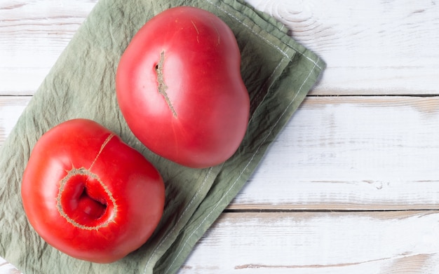 Dois grandes tomates vermelhos em um guardanapo verde