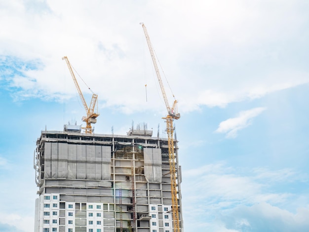 Dois guindastes de construção estão trabalhando na construção de edifícios altos, levantando e colocando coisas