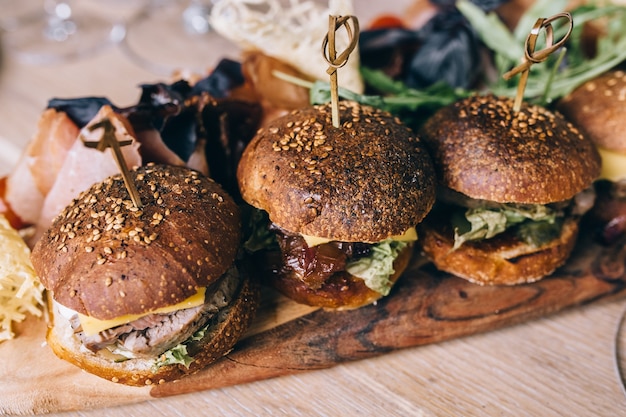 Dois hambúrgueres de carne caseiros com ovo na mesa de madeira.