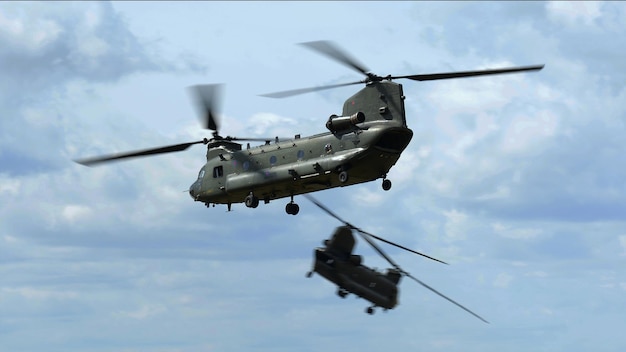 dois helicópteros voando no céu com um voando no ar