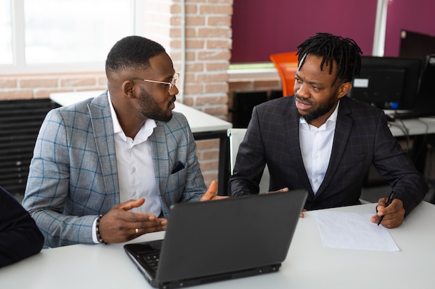 dois homens africanos no escritório com laptop