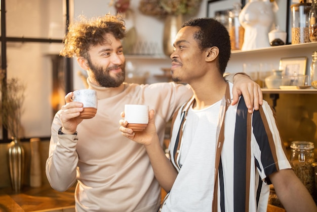 Dois homens conversando e tomando café na cozinha em casa