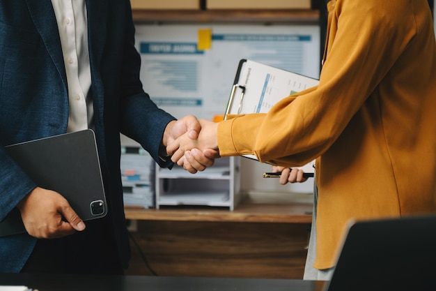 Foto dois homens de negócios confiantes apertando as mãos durante uma reunião no escritório cumprimentando o sucesso