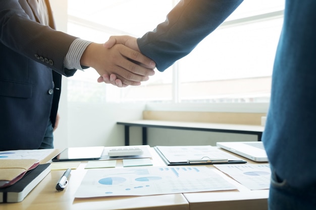 Foto dois homens de negócios confiantes apertando as mãos durante uma reunião no escritório, sucesso, trato, saudação e conceito de parceiro.