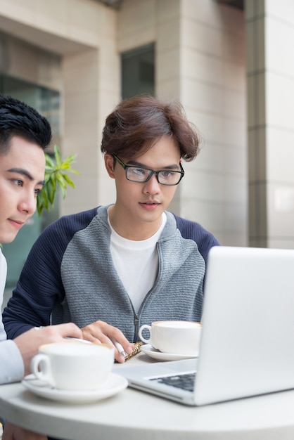 Dois homens de negócios sentados em um café discutindo um projeto de negócios