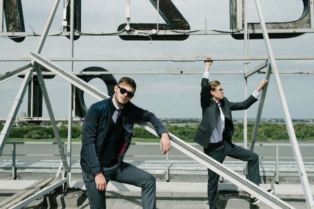 Dois homens de terno posando para uma loja de roupas masculinas.