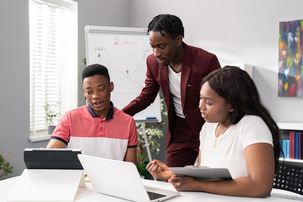 Dois homens e uma linda mulher sentam-se em um escritório de manhã se preparando para o trabalho