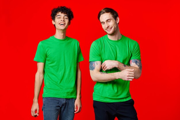 Dois homens em camisetas verdes riem da alegria da comunicação