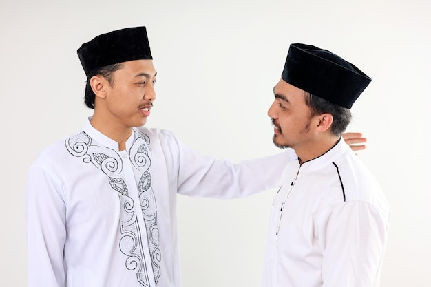 Dois homens muçulmanos asiáticos se abraçam e se perdoam celebrando o Eid Al Fitr