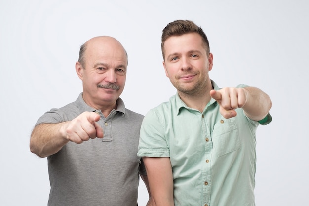 Foto dois homens pai e filho apontando para a frente