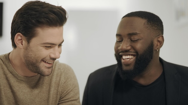 Foto dois homens sérios discutindo dados de trabalho em espaço aberto homem branco dando tapinhas no ombro