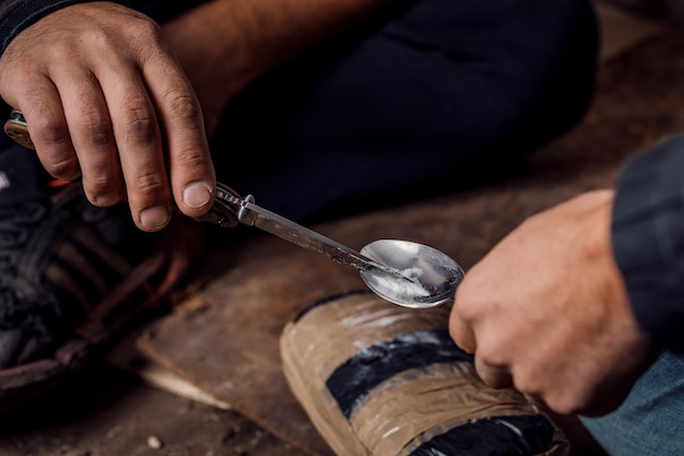 Foto dois homens surrados preparando injeção de drogas em favelas