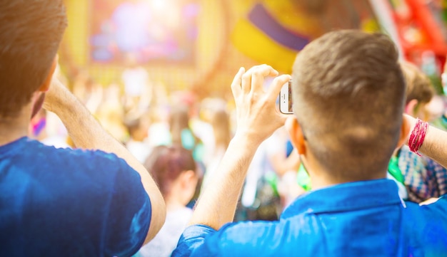 Dois homens tirando fotos nos smartphones em concerto ou festival