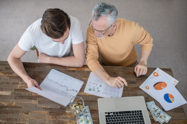 Dois homens trabalhando juntos em um projeto e parecendo concentrados