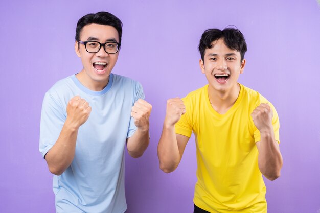 Dois irmãos asiáticos posando em fundo roxo