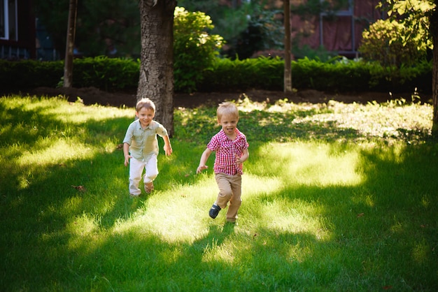 Dois irmãos de meninos brincando e pulando ao ar livre em um parque.