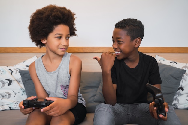 Dois irmãos jogando videogame em casa.