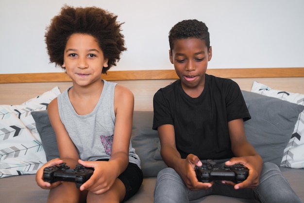 Dois irmãos jogando videogame em casa.