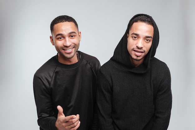 Dois jovens afro-americanos felizes em pé e posando