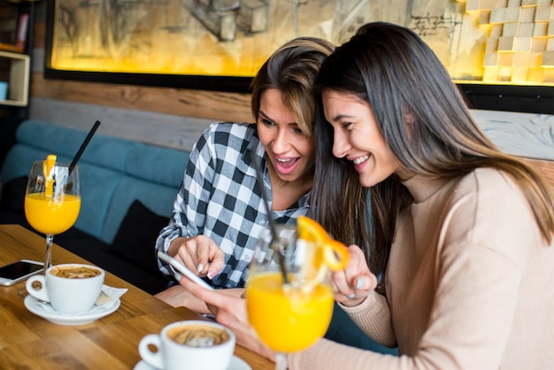 Dois jovens amigos femininos sentado no café