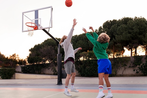 Dois jovens amigos jogando basquete em um conceito de quadra da cidade de esporte urbano no espaço de cópia de rua para texto