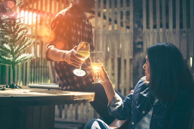 Foto dois jovens asiáticos quebram um copo de vinho em comemoração ao natal