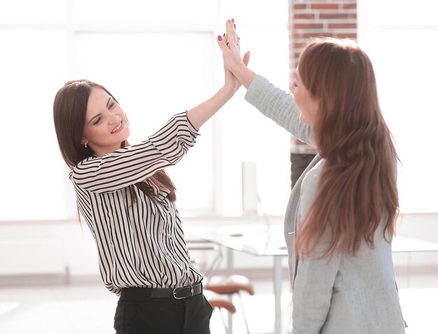 Dois jovens colegas de trabalho dando uns aos outros cinco