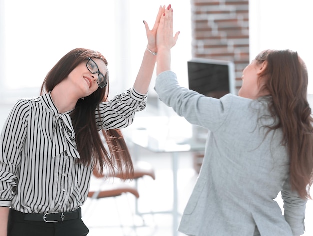 Dois jovens colegas de trabalho dando uns aos outros cinco