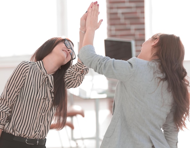 Dois jovens colegas de trabalho dando uns aos outros cinco