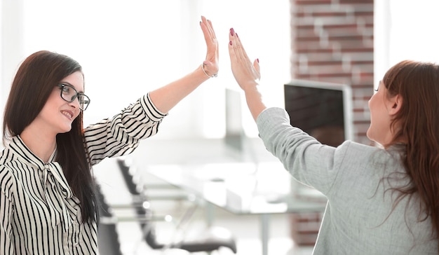 Dois jovens colegas de trabalho dando uns aos outros cinco
