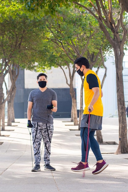 Dois jovens com máscaras fazendo exercício juntos