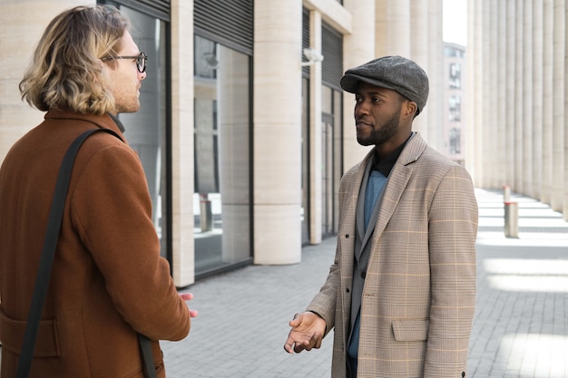 Dois jovens conversando em pé na rua