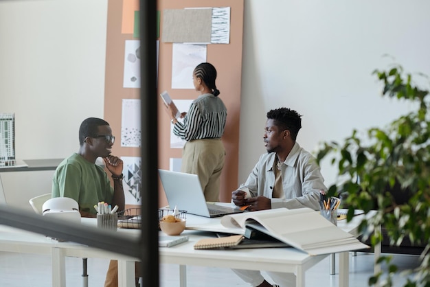 Dois jovens designers masculinos confiantes fazendo brainstorming e discutindo novas ideias