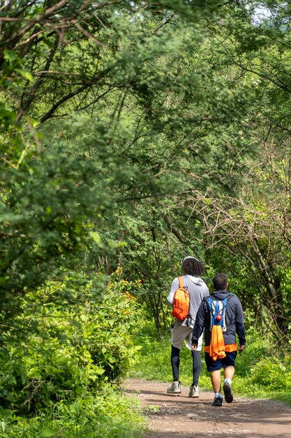 Dois jovens e amigos descendo na vegetação da ravina e árvores huentitan ravine guadalajara méxico