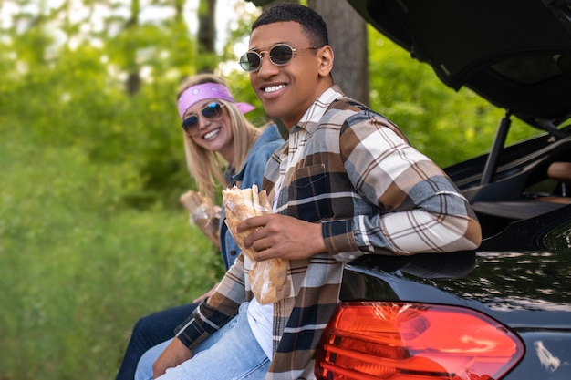 Dois jovens em óculos de sol sorrindo e parecendo satisfeitos