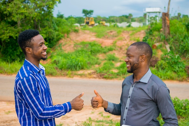 Dois jovens empresários africanos trocando apertos de mão por causa de um negócio fechado.