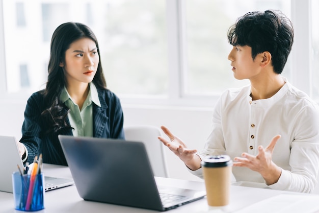 Dois jovens empresários asiáticos debatem projeto de fim de ano