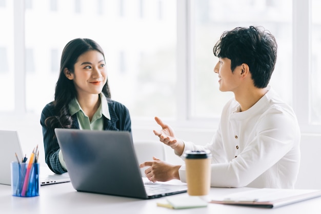 Dois jovens empresários asiáticos discutem projeto de fim de ano