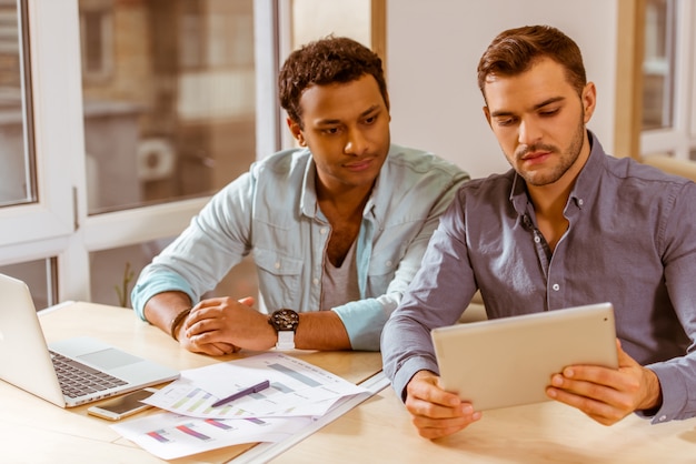 Foto dois jovens empresários bonitos no trabalho.