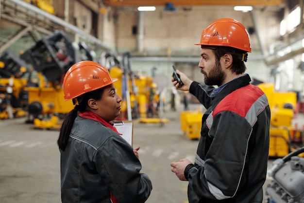 Dois jovens engenheiros confiantes em roupas de trabalho discutindo