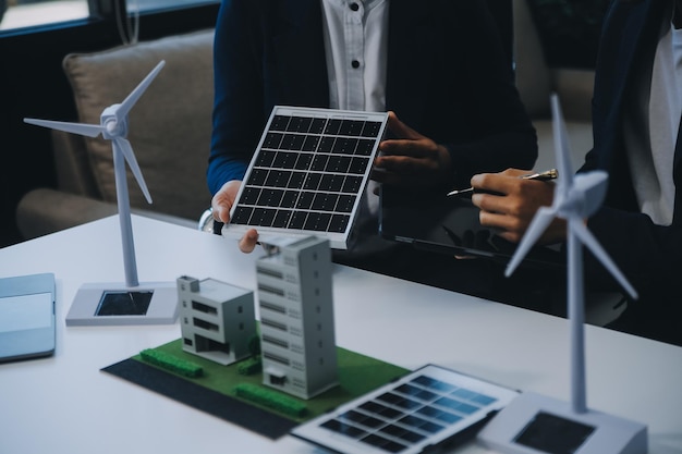 Dois jovens engenheiros especializados na instalação de células solares Reuniões e discussão no trabalho Planejamento para instalar painéis fotovoltaicos solares no telhado da sala de escritórios com plano de construção da fábrica