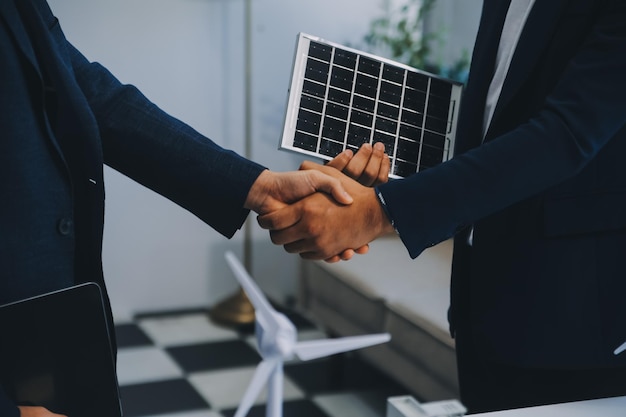 Dois jovens engenheiros especializados na instalação de células solares Reuniões e discussão no trabalho Planejamento para instalar painéis fotovoltaicos solares no telhado da sala de escritórios com plano de construção da fábrica