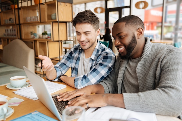 Dois jovens estudantes discutindo coisas importantes durante o processo de estudo no refeitório.