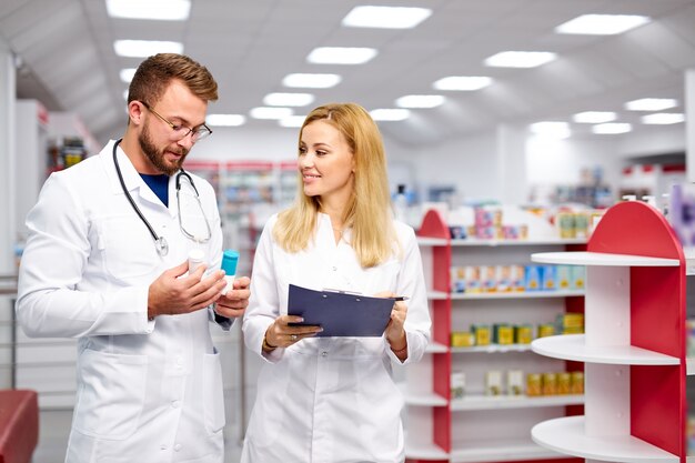 Dois jovens farmacêuticos caucasianos estão discutindo medicamentos